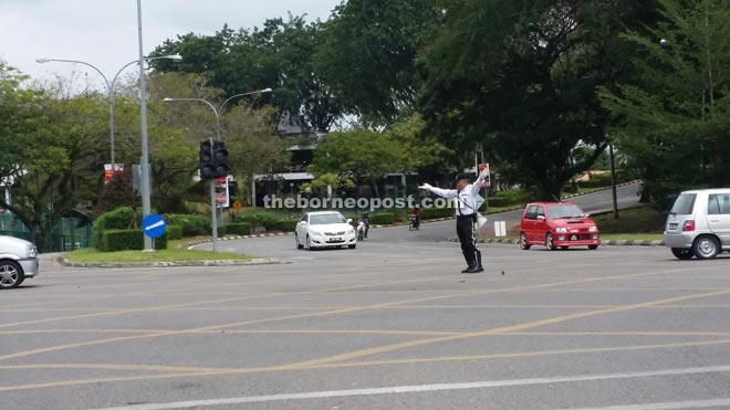 A traffic policeman regulating traffic in Kuching to ensure smooth and safe traffic flow. — Photos by Joanna Yap