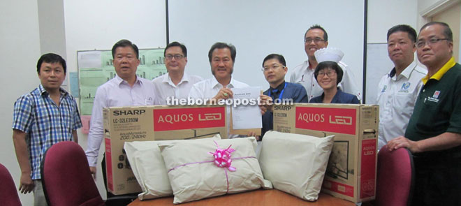 Hii (fourth left) hands over the items to Miri Hospital director Dr Jack Wong.