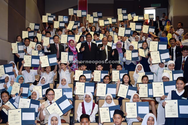 (Centre row, from left) Su, Rakayah and Abdul Rahman giving the thumbs-up while students show off their UPSR results. — Photo by Tan Song Wei