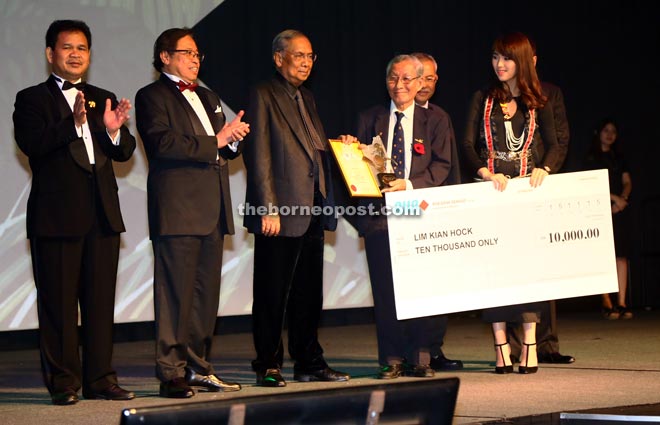 Winner Lim Kian Hock receiving his award under the Hornbill Special Awards category from Adenan (third from left). Sarawak Tourism Board CEO Datu Ik Pahon Joyik is on the left, Abang Johari on second left and partly hidden is Assistant Minister of Tourism Datuk Talib Zupilip. — Photo by Muhamad Rais Sanusi