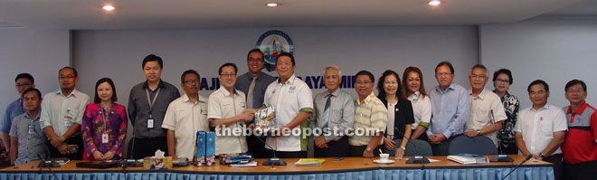 Lai (10th right) presents a souvenir to Choo, as the councilors and MCC staff members look on.