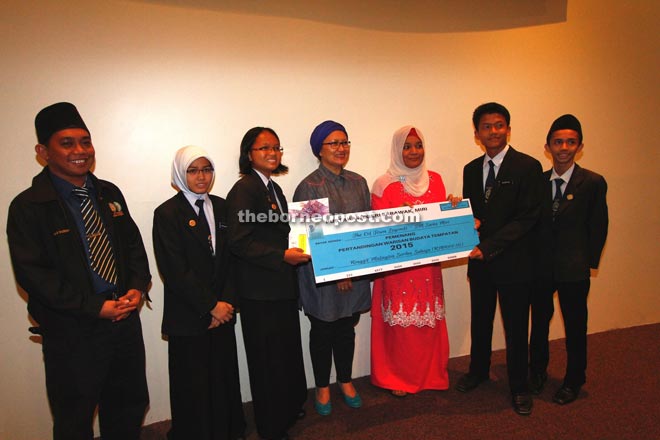 Rashidah (fourth left) and Salina (third right) present the mock cheque and certificates to the winners of the competition.