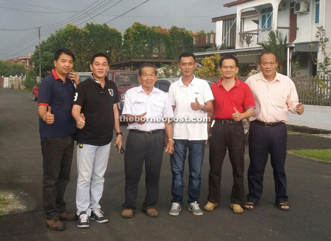 Chiew (second left) and other UPP Pelawan members give the thumbs-up to the road upgrading works.