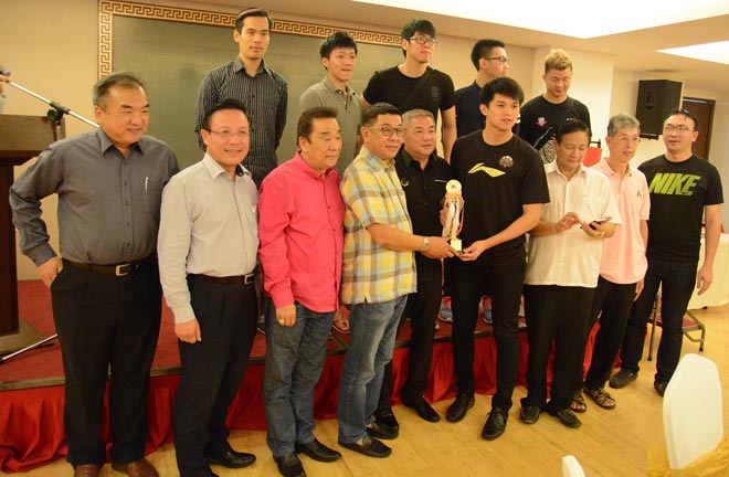 Men’s team captain Iversen Tu Chu Soon (fourth right) presents the champion’s trophy to Richard Wee (fourth left) while Sarawak Basketball Association president Michael Teo (third left), KDBA honorary president Wong Tiong Hock (third right), KDBA officials and players look on.