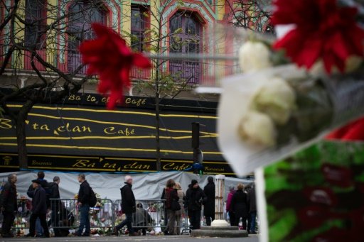 © AFP/File / by Pauline Talagrand et Nicolas Gaudichet | People walk by the Bataclan concert hall, where, on November 13, jihadists armed with AK47s and suicide vests killed 90 people in the bloodiest of a wave of attacks across the French capital, on November 30, 2015 in Paris 