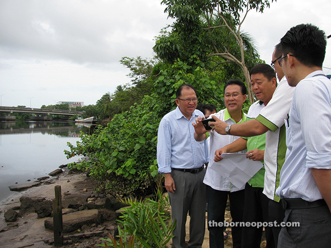 Councillor Bruce Chai (second right) showing Lai (third right), councillors Peter Chia (left), Julaihi Mohamad (second left) and others the conceptual design of the Kampung Pangkalan Lutong waterfront on his phone.