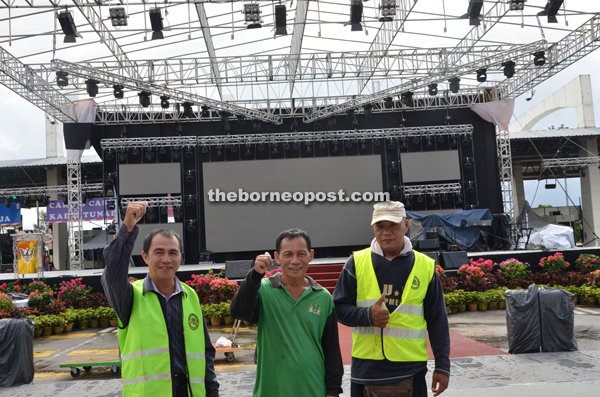 Kuching North City Commission (DBKU) workers (from left) Salleh Bol, Lajep Juan and Ariffin Sabu give their thumbs-up to the abolishment of the bridge toll.  
