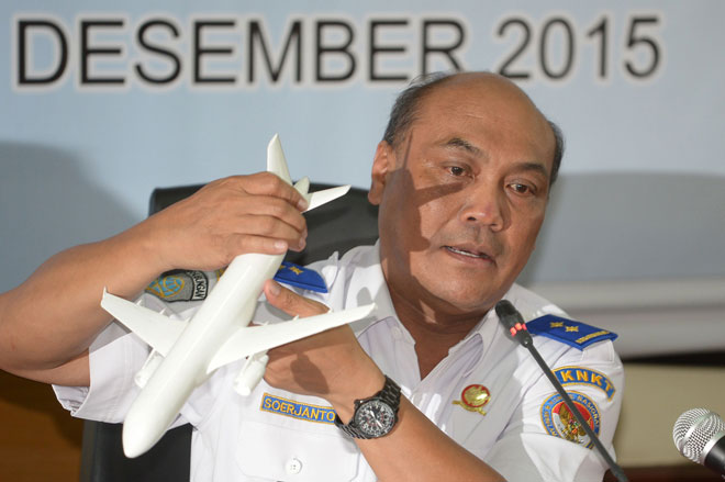 Soejanto Tjahjono, head of Indonesian National Transportation Safety Committee,  holds a plane model as he speaks to journalists in Jakarta on the Flight QZ8501 investigation. — AFP photo
