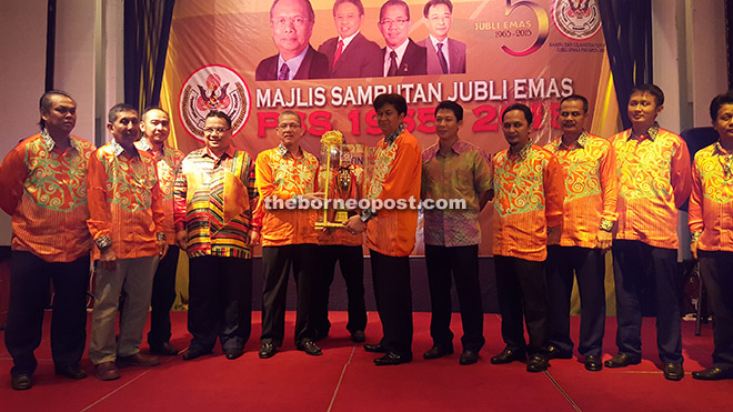 Fadillah (fifth, left) receiving the tournament challenge trophy from Abang Khalid (fifth right) during the dinner.