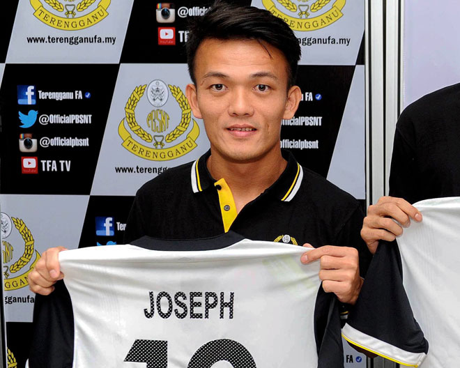 Joseph Kallang Tie holds his jersey after signing his contract with Terengganu yesterday. — Bernama photo