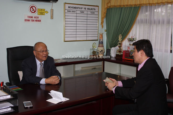 Minos (left) discusses some points with SDC secretary Simon Wong Hong Yong. — Photo by Churchill Edward