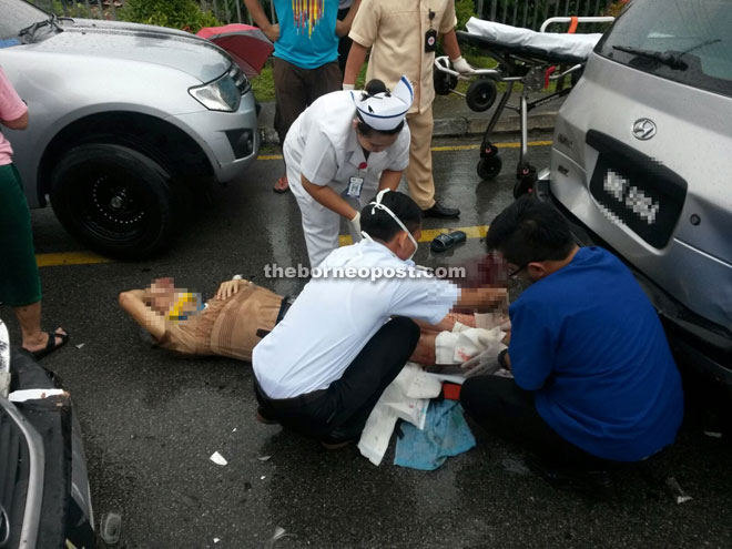 Medical personnel attend to the elderly man at the accident scene. 