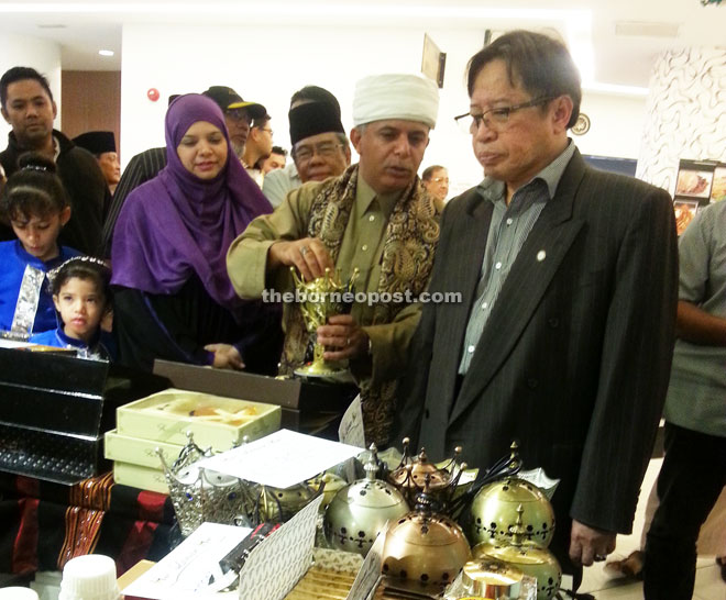 Abang Johari (right) listens to an explanation from Helmi (second right) while visiting a booth at the Yemen Festival.