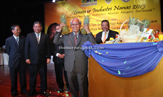 Jabu, after launching the Pineapple Industry Seminar 2015, reacts to the press photographers by holding up two MD2 variety pineapples over his shoulders for comic relief. Also seen from left are Mong, Nogeh and Sahdan (right).