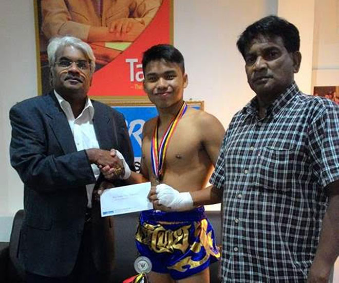 Kabilan receiving the cheque from Siva while his proud father G Thiyagarajan, an ex-RMAF serviceman, looks on.