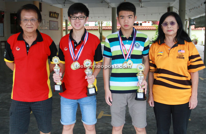 Chua (left) and Wee posing with top performers Jason Siaw Ting Shen (second left) and Christopher Goh Kho Hian Hui.