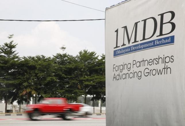 Traffic passes a 1Malaysia Development Berhad (1MDB) billboard at the Tun Razak Exchange development in Kuala Lumpur, Malaysia, July 6, 2015. REUTERS/Olivia Harris