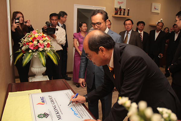 Entri signs the plaque at the joint launching of the Mekong Group with Vongsey in Phnom Penh. 