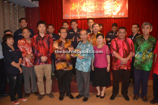 Ho (front fourth right) presents the book ‘Malaysia’s 100 Leading Coffee Shops and Restaurants’ to Jamit. Kapit Coffee Shop and Restaurant Owners’ Association adviser Larry Sng is at front third left while Temenggong Tan Kian Hoo is at front second right.