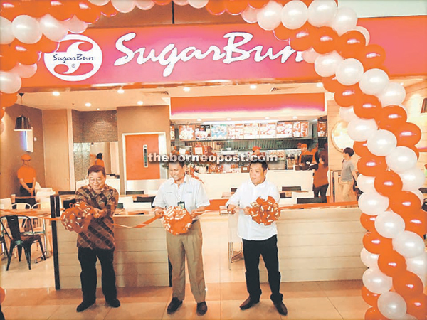 Song (right) with Yeo (left) and Nadzim (centre) cutting the ribbon at the opening of Sugarbun outlet, KIA.