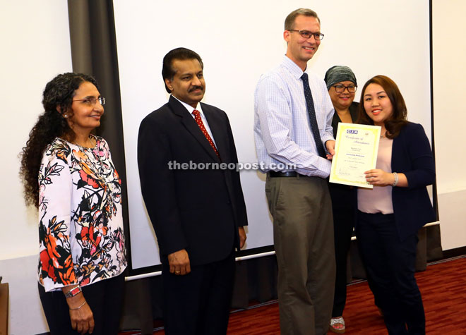 The Borneo Post reporter Marilyn Ten receives a certificate of participation from Weisert.