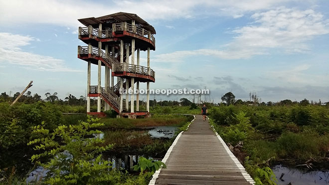 A visitor passes by the lookout tower in the park, which is no longer accessible.