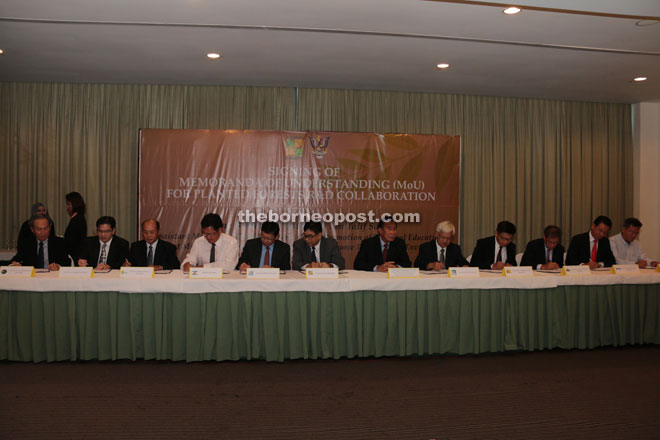 Ting Chung (sixth left) and others sign the MOUs, as Len (sixth right) looks on.