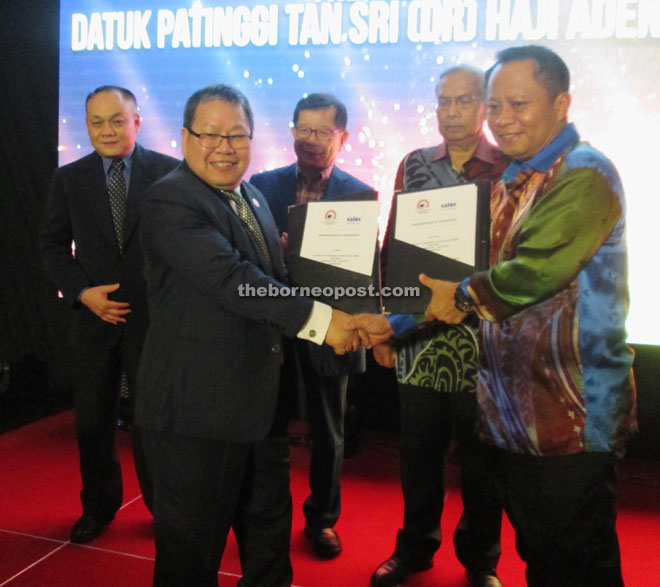 Exchange of MOA documents between Sains represented by Teo (left) and Centexs director Dato Mohd Abu Bakar Marzuki, witnessed by Adenan, Chan and Sains chief operating officer Teo Loon Tong.