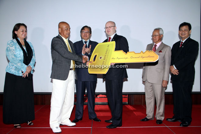 Warmington (third right) hands over a mock key to Samat witnessed by Abang Johari (third left). Gracie is at left. — Photo by Chimon Upon