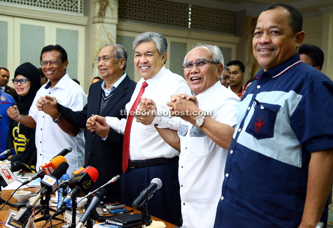 Zahid (third right), together with (from second left) Ahmad Shabery, Adenan, Jabu and Shahidan, raise their hands together in show of unity in the nation’s effort to manage natural disasters. — Photo by Muhammad Rais Sanusi