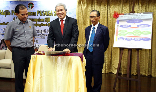 Awang Tengah (centre) signing 2016 STIDC Strategic Map during the monthly meeting yesterday. He is flanked by Sarudu (right) and Hashim.