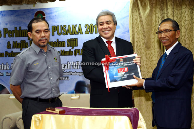 Awang Tengah receiving STIDC’s 2016 Balanced Scorecard from Sarudu (right). With them is Hashim.