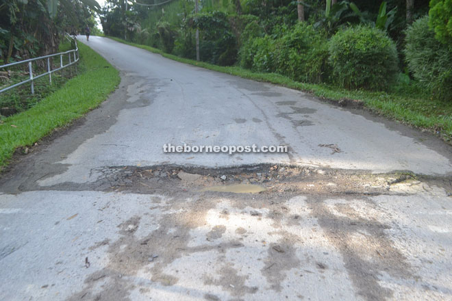 The damaged section of the road which villagers want repaired.