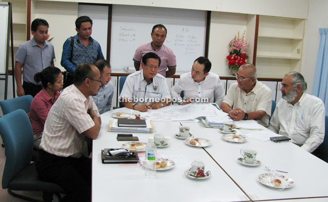 (Seated fourth from left) Lee, Lau, Yii and Karambir together with the representatives from MCC, JKR and L&S Department looking at the drainage project plan for Miri during the meeting.  