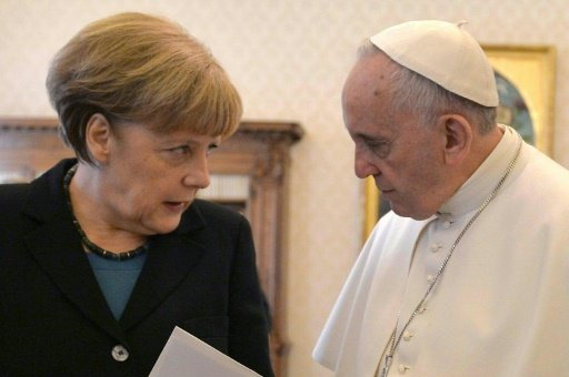 Pool/AFP | Pope Francis speaks with Angela Merkel during a 2015 meeting at the Vatican 