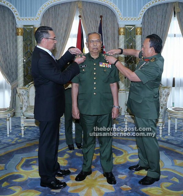 Hishamuddin (left) and Zulkifeli put the rank on Adenan who was dressed in Territorial Army uniform