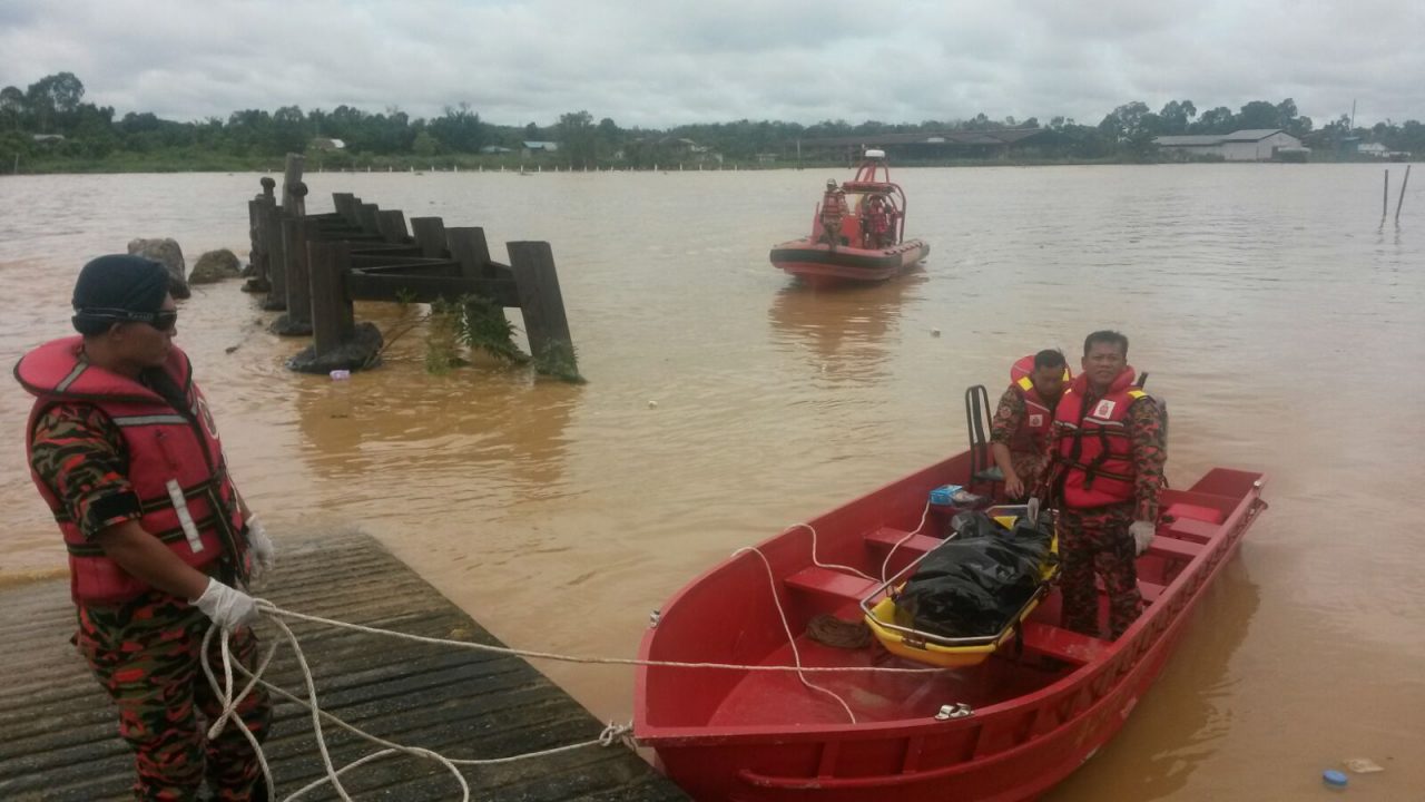 Bomba personnel bring Ricky's body ashore after recovering it from Sungai Antu.