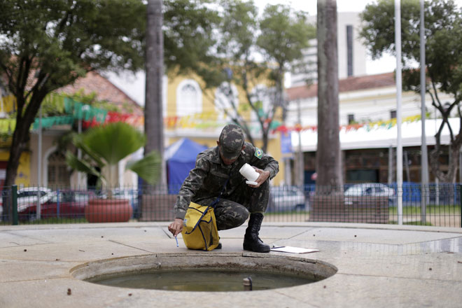 Brazilian soldiers conduct an inspection for the Aedes aegypti mosquito on a street in Recife Brazil. — Reuters photo