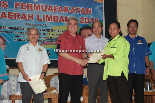 Awang Tengah, flanked by Paulus (left) and Dr Rahman (extreme right), handing over appointment letter to one the community leaders in Limbang Division.