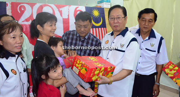 Temenggong Dato Lau (second right) and Julaihi (third right) handing over the CNY gifts to a recipient at Chung Ching Kindergarten at Sg Ma’aw. 