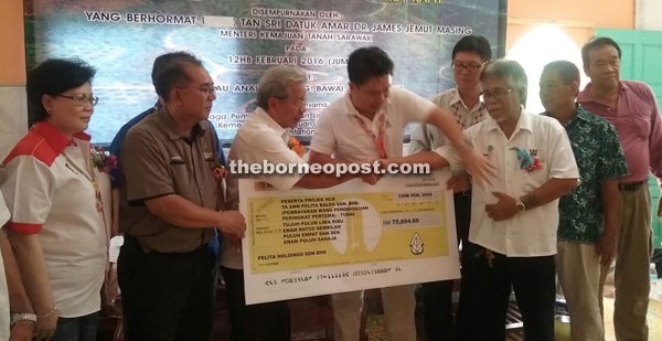 Masing (third left) symbolically hands over the money to Area Development Committee chairman Penghulu Undi Bajai. At left is Senate deputypresident  Datuk Doris Sophia Brodie.