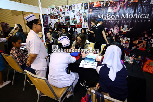 Visitors crowd the Maison Monica booth to learn all things related to beauty.