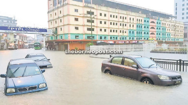 Cars attempt to move through rising flood waters at Jalan Masjid. 
