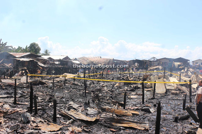 Investigators marking the house, which is believed to have started the fire, with a yellow line.