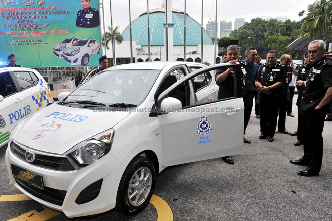 Khalid (left) takes a closer look at a Perodua Axia police patrol car during the ceremony. Also present are Crime Prevention and Community Safety Department director Datuk Acryl Sani Abdullah Sani (right). — Bernama photo