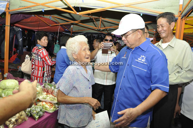 Maximus (second left) exchanging festive greetings with Chee, the oldest woman in Kota Marudu at 90.