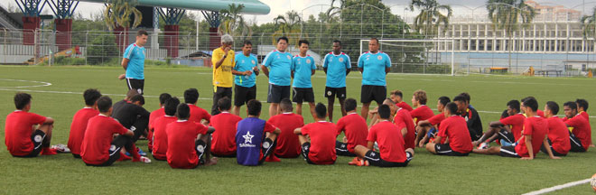 Coach Rajagobal (second left) giving a pep talk to the players and assistant coaches after a training session.