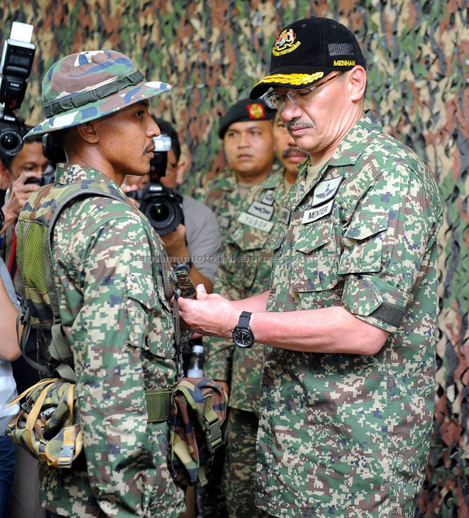 Hishammuddin (right) pins the badge on Private Nor Sharani Shamsul Kamal to mark the latter’s promotion to Lance Corporal during the minister’s visit to the Joint Border Post of Malaysian Armed Forces-Indonesian National Army near Lundu. — Bernama photo