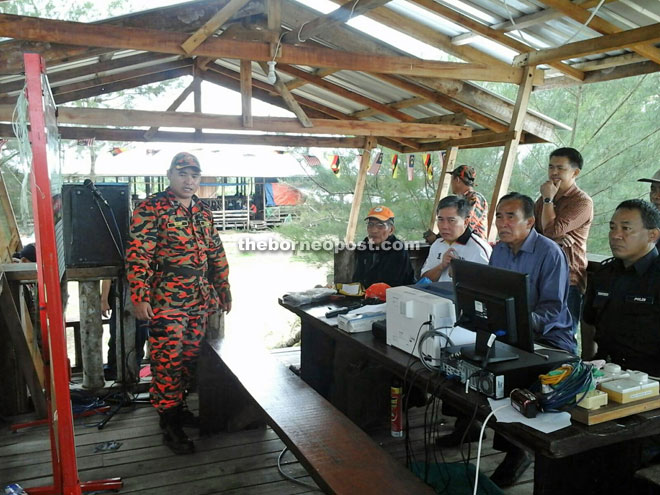 Fire and Rescue officer Terry Robson (left) is seen briefing Len (second right) and others at the SAR operation centre. 