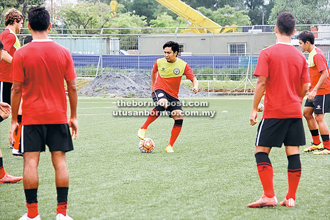 BERSEMANGAT: Syahrul (tengah) bersemangat menjalani latihan bersama rakan-rakan sepasukan di Stadium Negeri Kuching semalam.